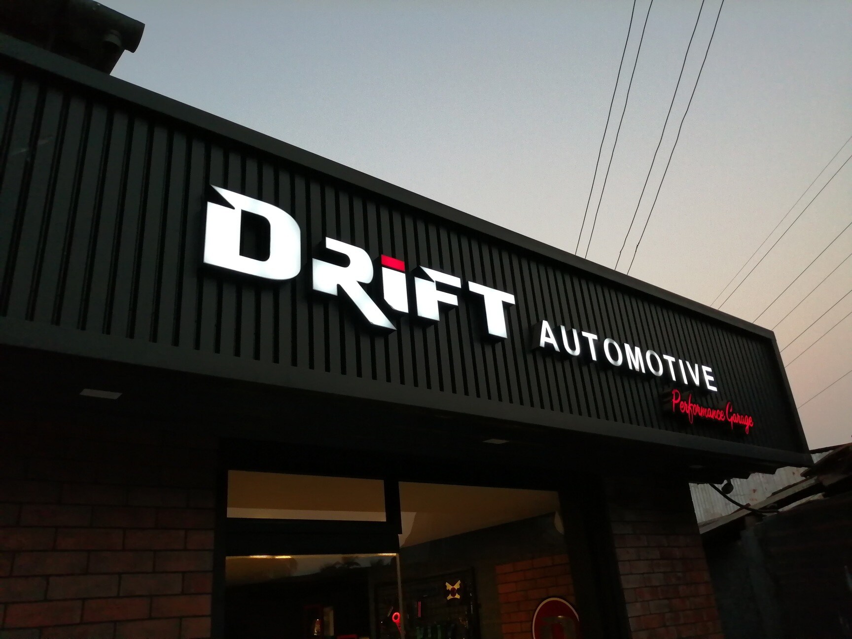 Drift Automotive Performance Garage signage at twilight