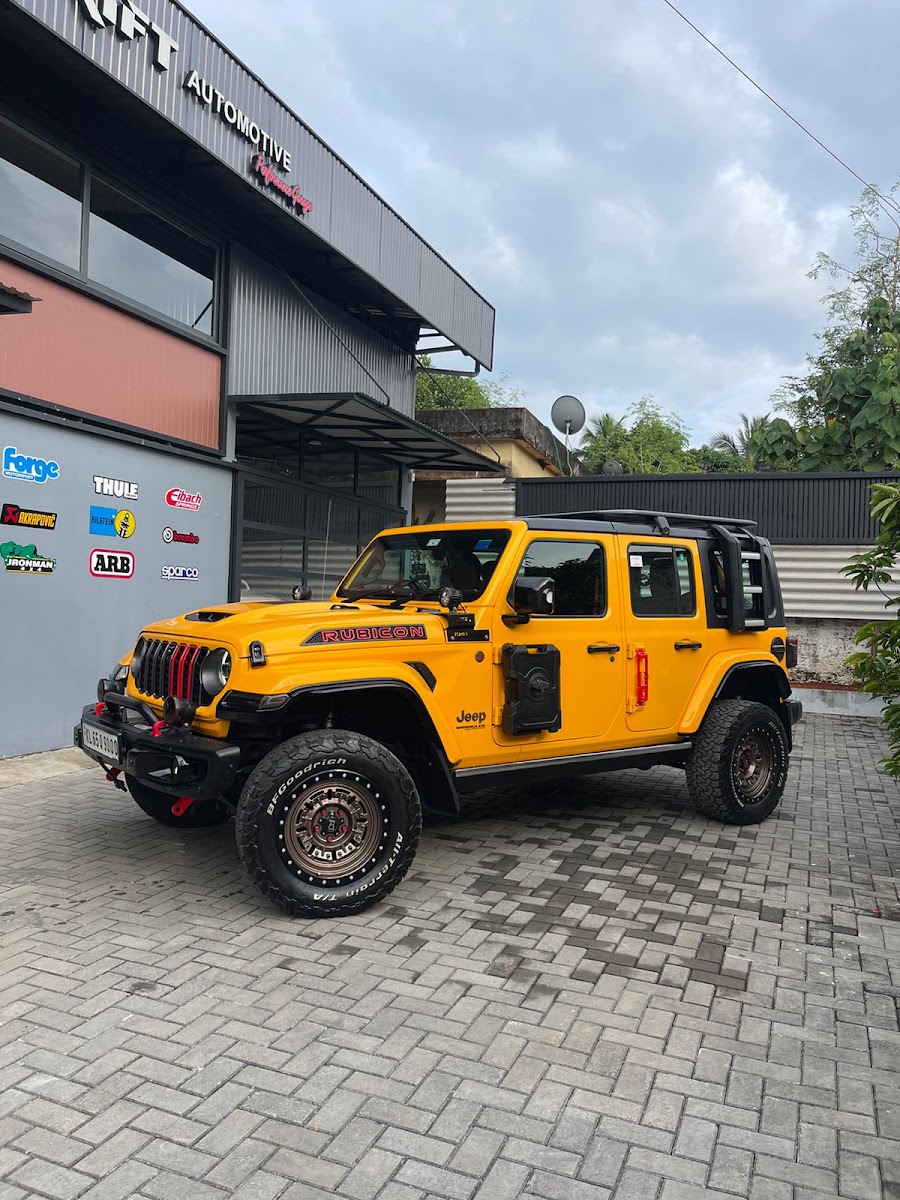 Lifted yellow Jeep Wrangler Rubicon on mud-terrain tyres outside Drift Automotive